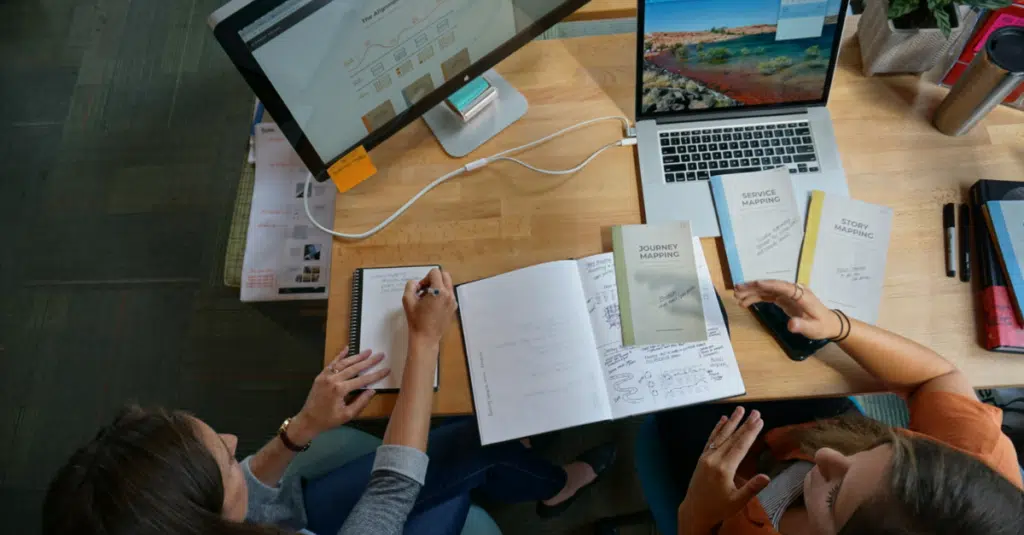 5 Myths of Custom Software Development (And Why They're No Longer True) 1 Image of brainstorming team members discussing custom software development myths that aren't true anymore.