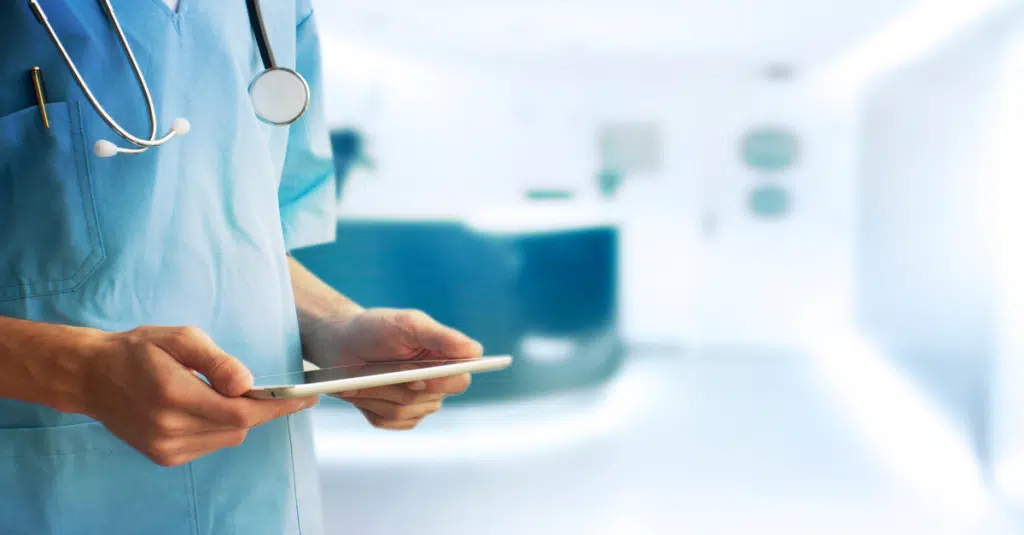 Beginner's Guide: HIPAA Compliance and Software Development 1 An image of a doctor reading a tablet for a blog about HIPAA compliance and software development.