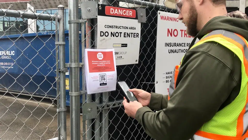 Benefits of Construction Mobile Apps for Your Crews and Projects (and Real Examples) 4 Worker at construction site uses a health screening app made by SPARK